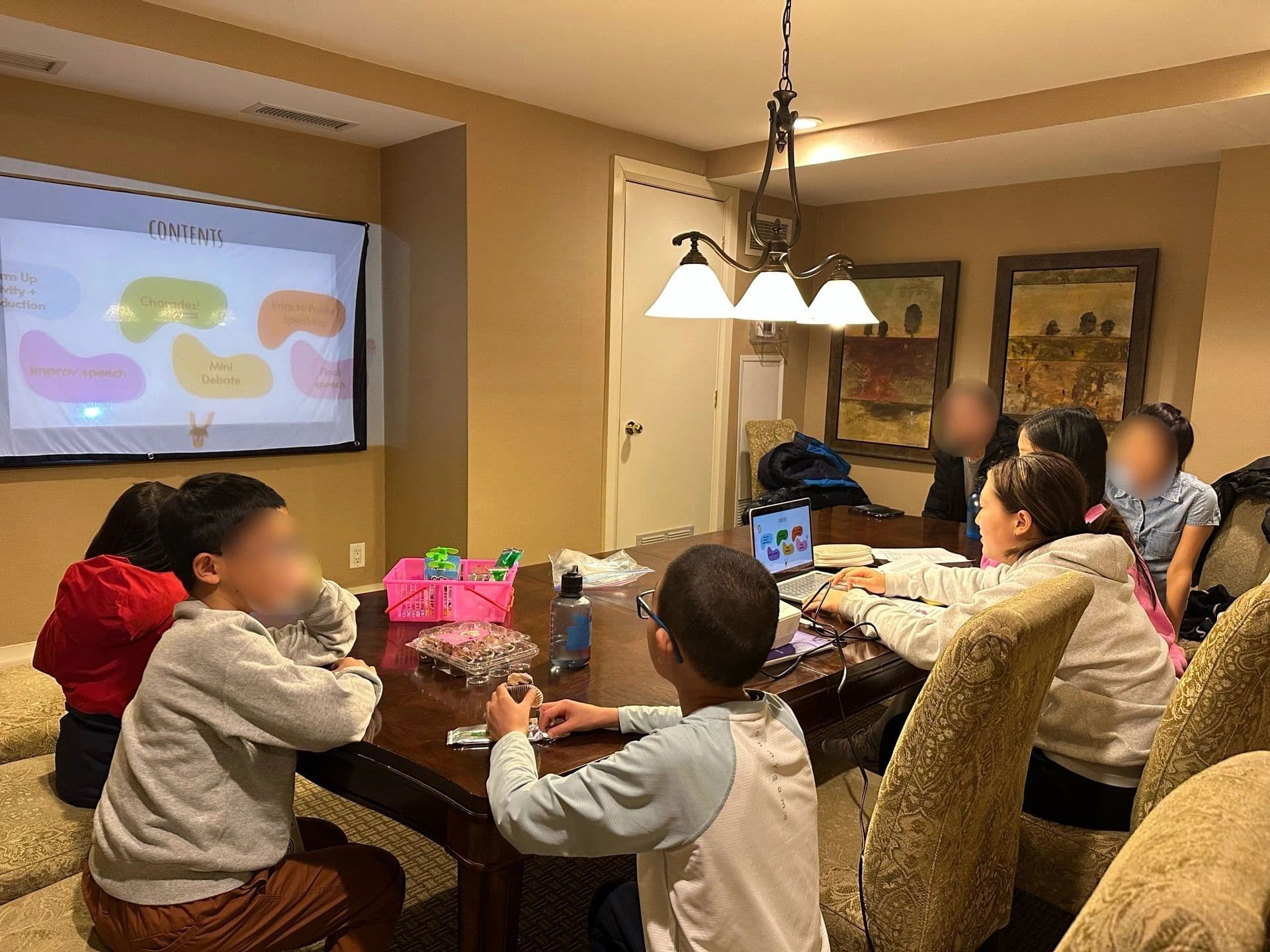 Children in a group learning session with a projector and laptop.
